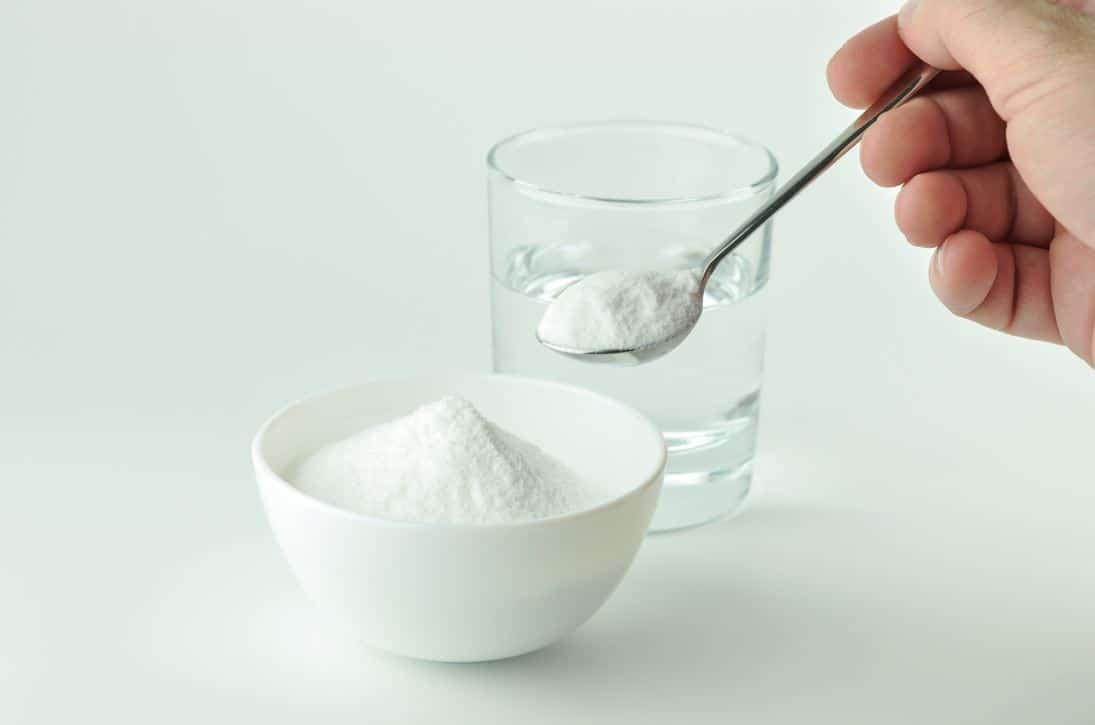 man holding tea spoon of baking soda