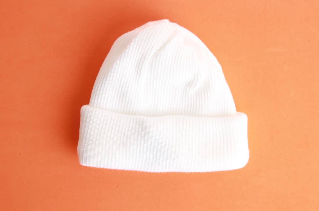 woolen white beanie on an orange background