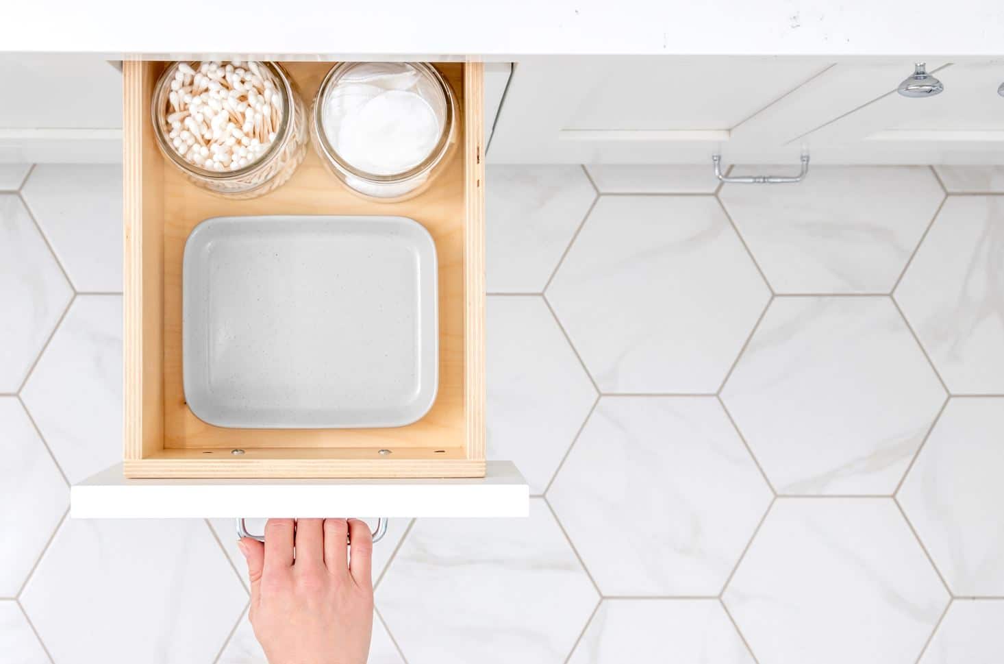 woman opening full kitchen cosmetic cabinet