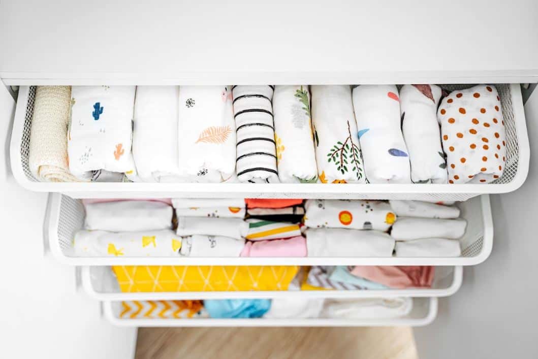 assorted baby clothes folded neatly into five different containers