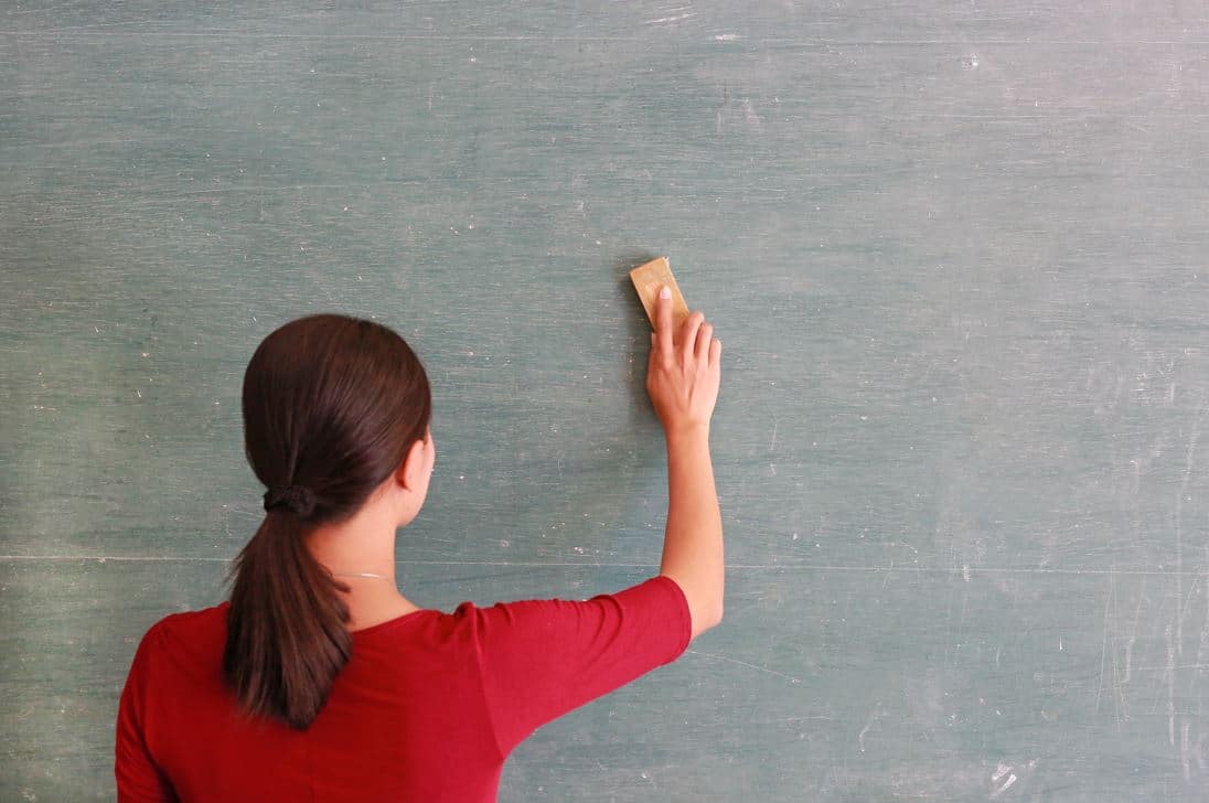 lady with red t-shirt cleaning dirty chalk board