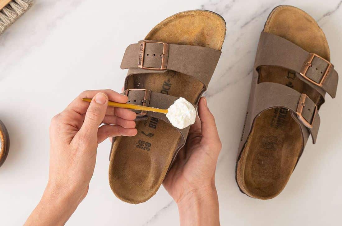 man using baking soda to clean dirty birkenstock sandals