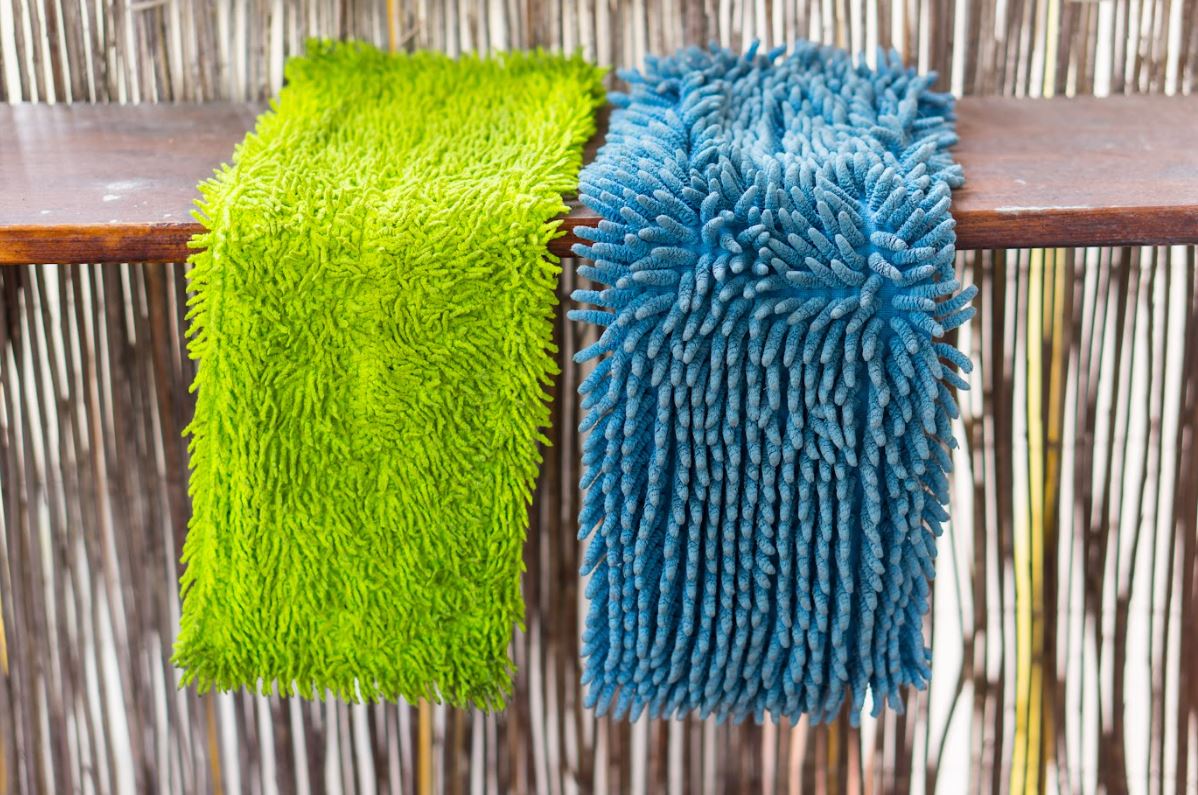 dust mop pads drying on a wooden bench