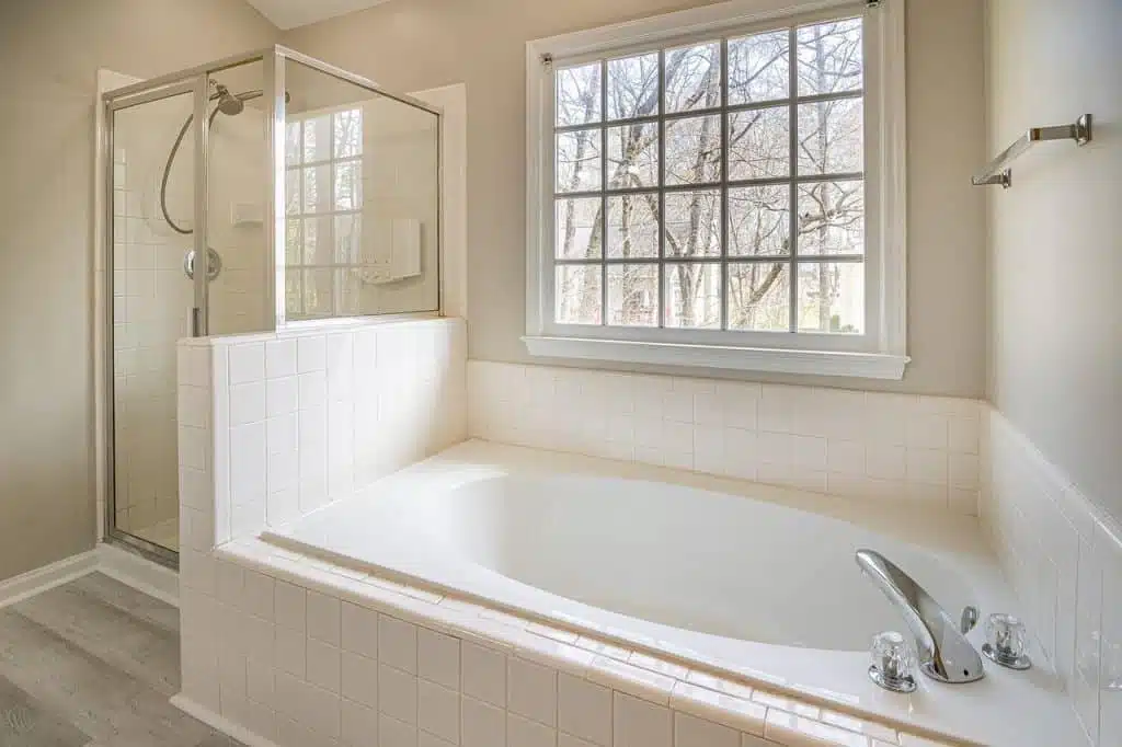A white bathtub next to a white framed window