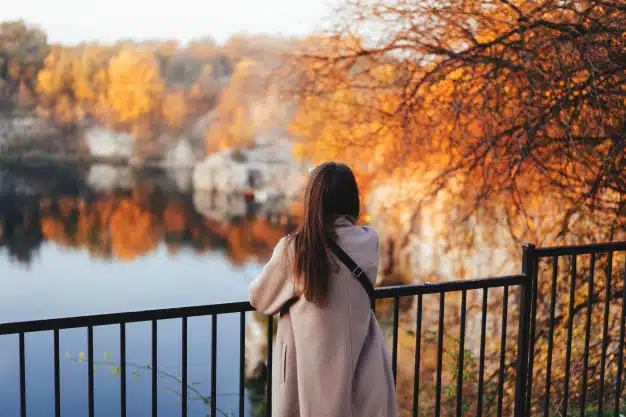 Autumn girl standing backwards watching nature