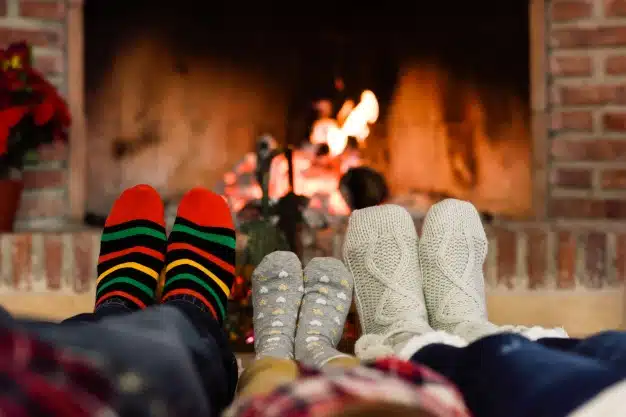 Feet christmas socks near fireplace relaxing