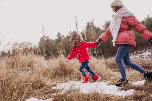 Mother with little daughter in winter forest