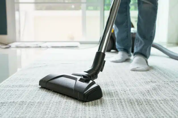 women-using-vacuum-cleaner-cleaning-carpet-living-room