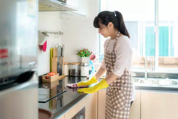 Woman cleaning kitchen cupboard