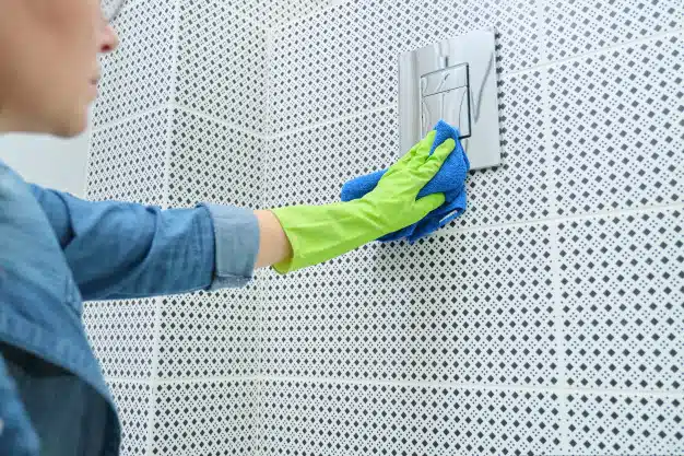 Woman cleaning polishing tiled wall