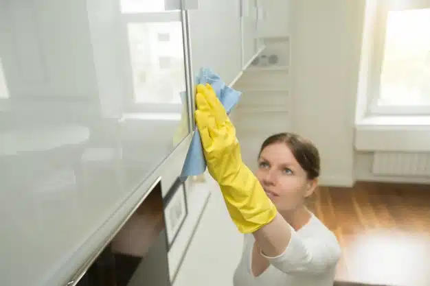 Woman cleaning upper surface storage