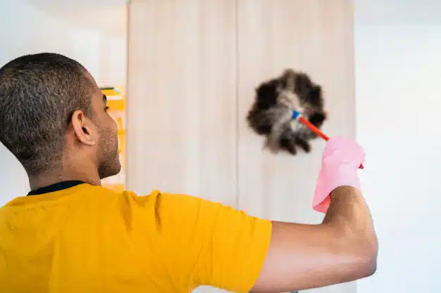 Man dusting his cabinet