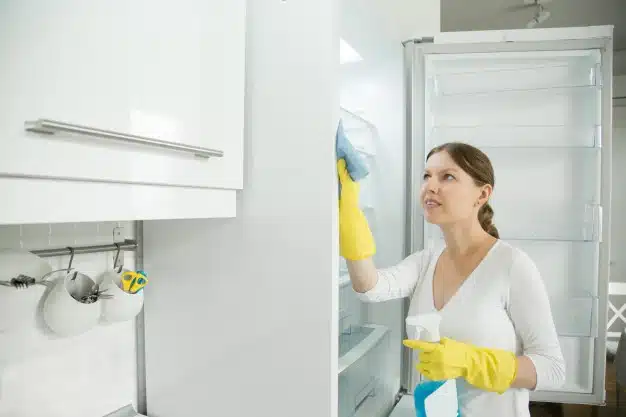 Woman cleaning fridge