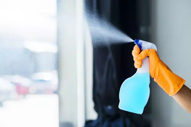 close-up-person-s-hand-spraying-liquid-detergent-window
