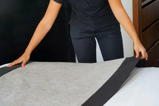 maid making bed hotel room