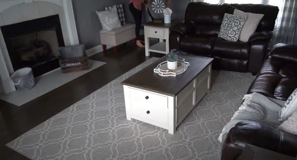 Cleaning lady wearing pink singlet vacuuming a living area