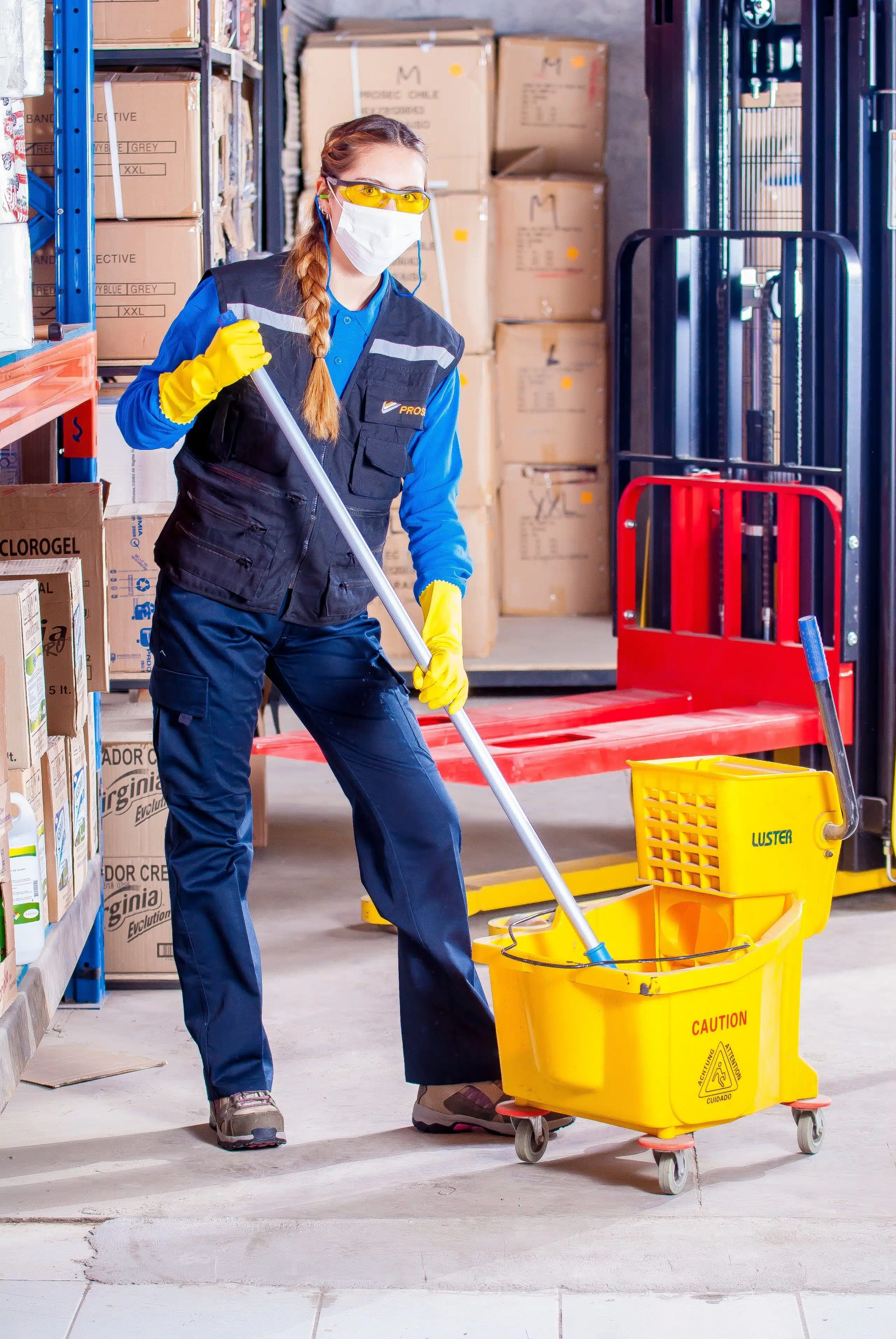 Professional cleaner wearing overrals with a mop and bucket