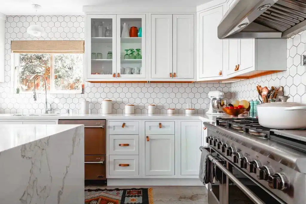 An all white kitchen with white cupboards and a white marble benchtop