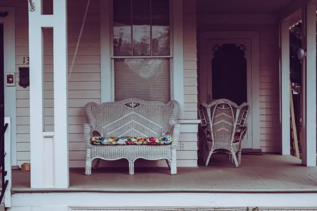 Two wicker chairs on a front porch