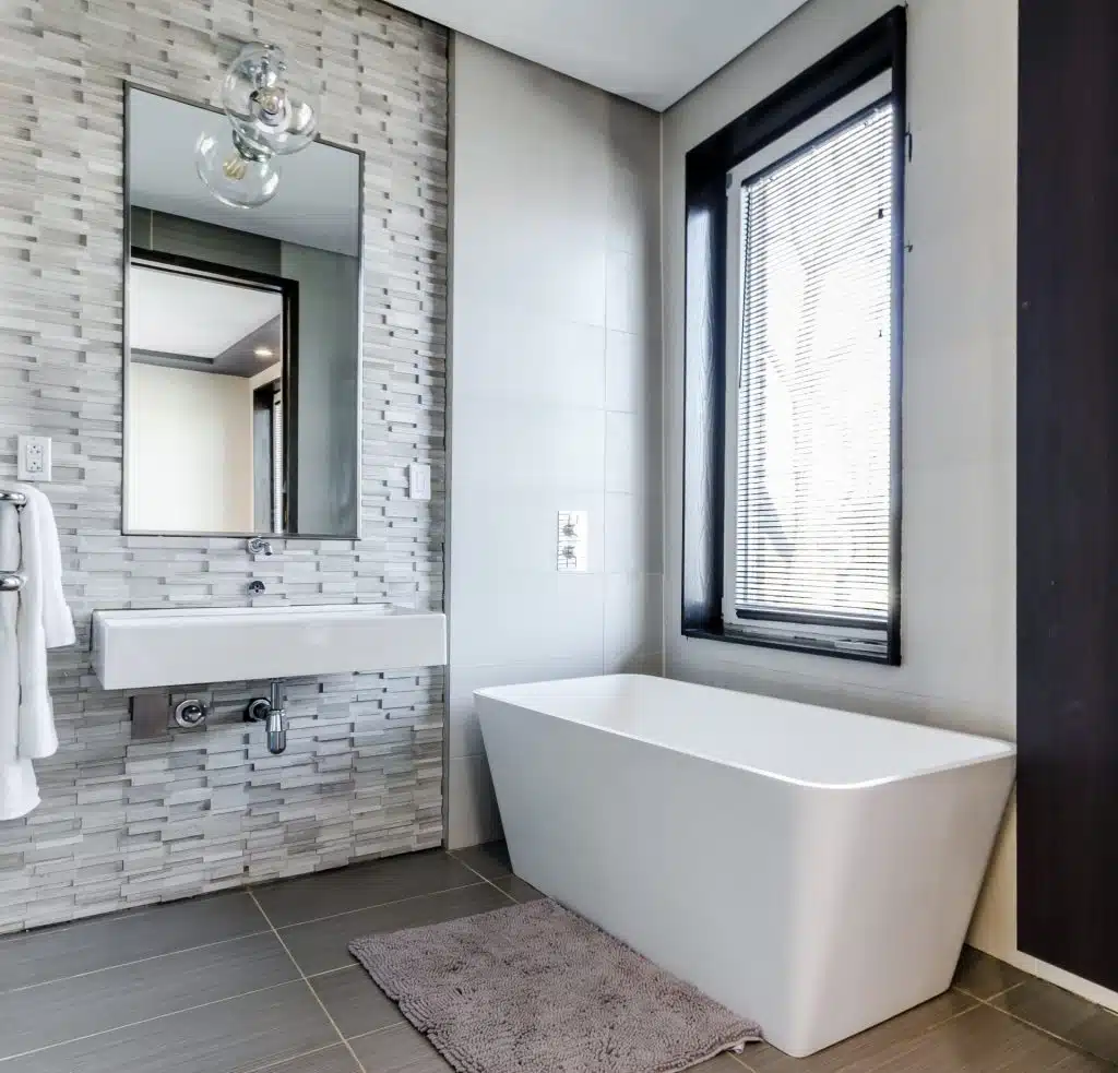 A white ceramic bathtub in an all white bathroom