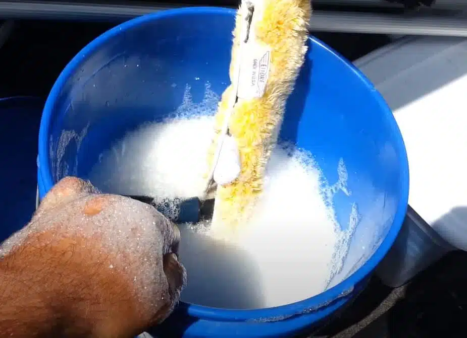 A blue bucket filled with soapy water