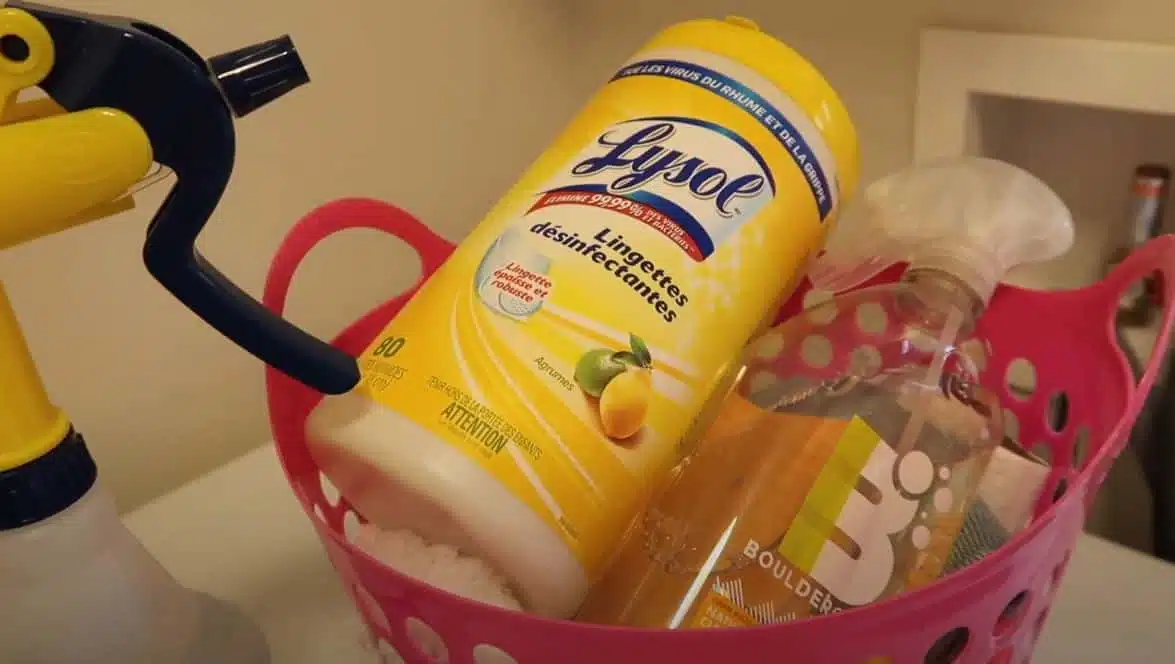 A pink container filled with cleaning chemicals and rags