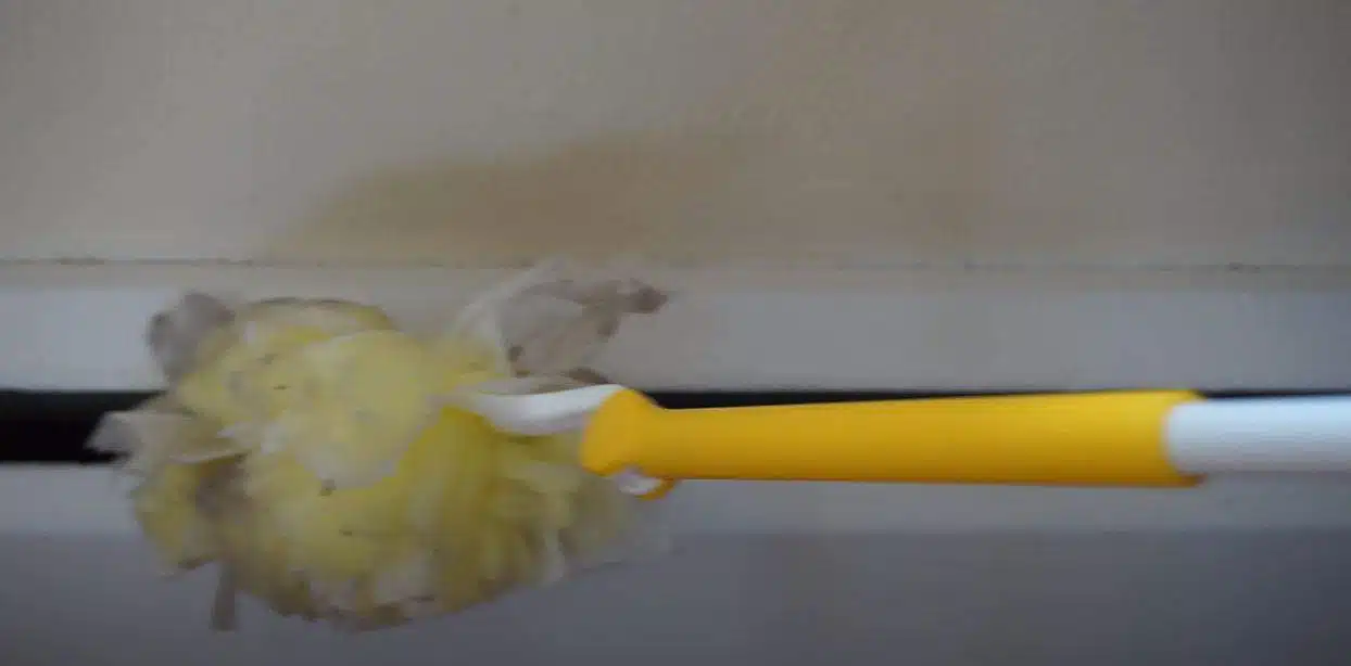 a yellow feather duster cleaning skirting boards