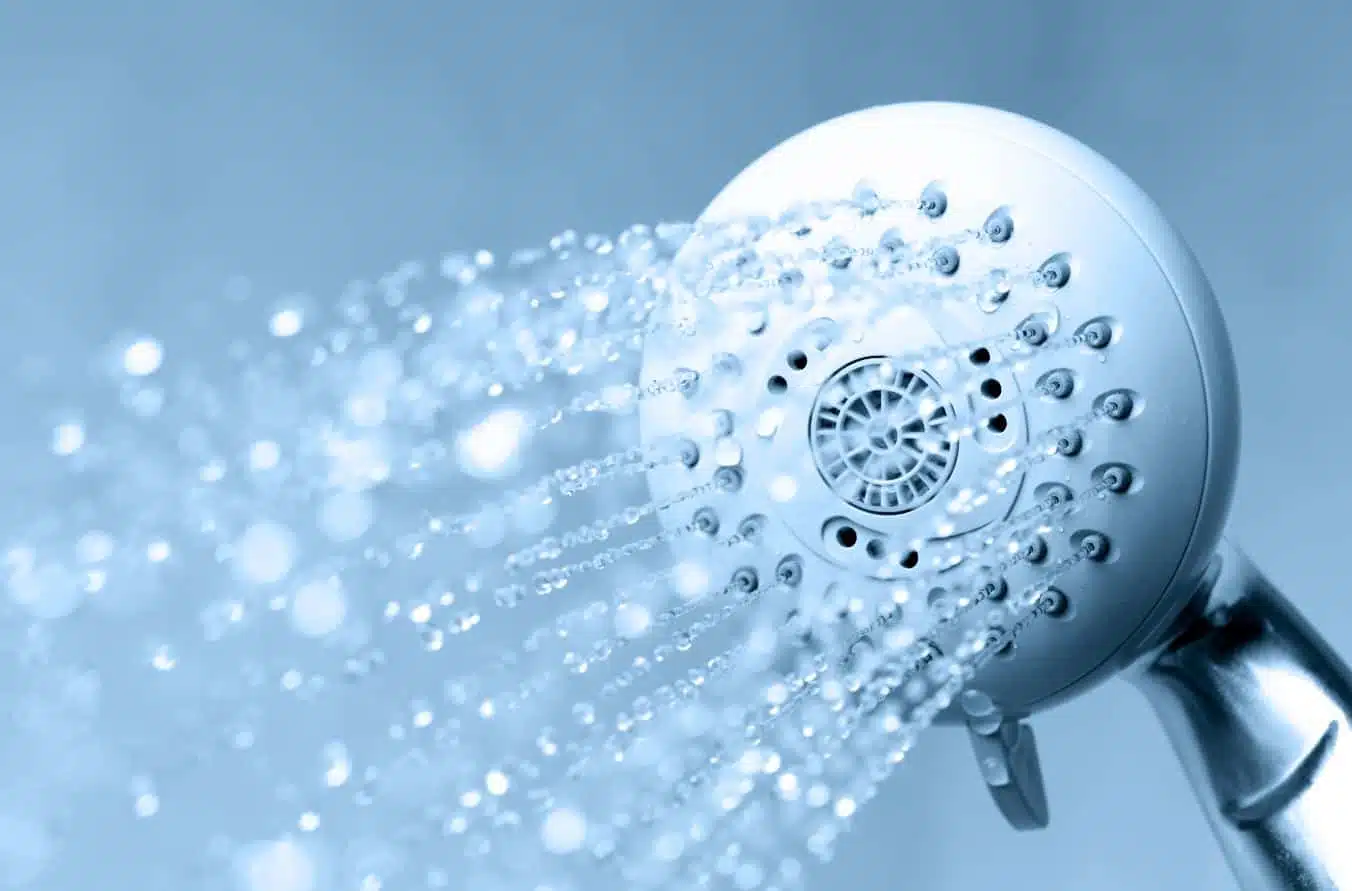 a close up of a shower head with the faucet turned on