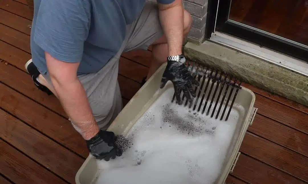 washing grill with scourer in large plastic bucket