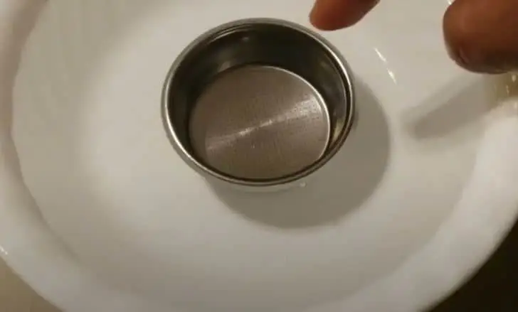 coffee filter being cleaned in a bowl