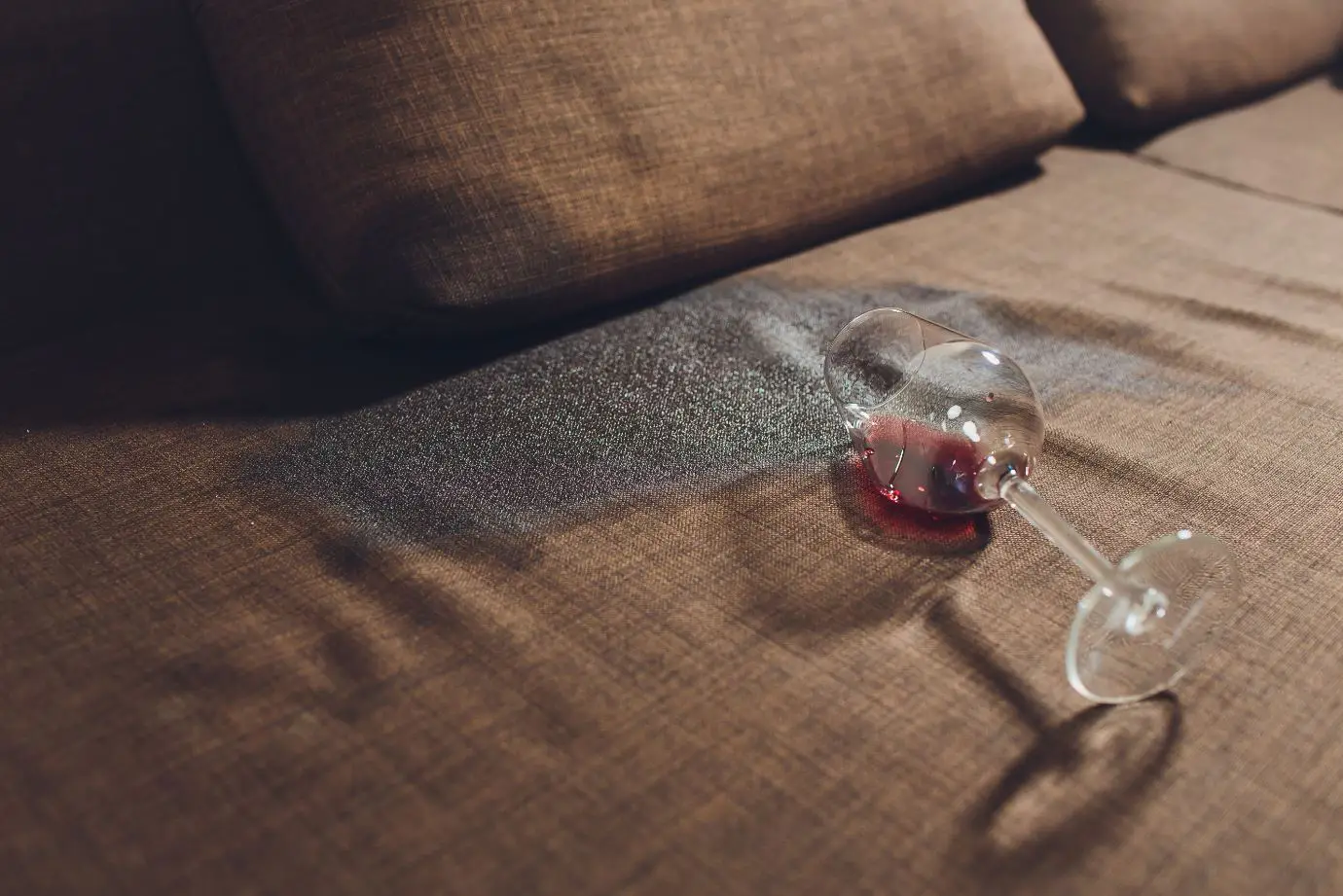 red wine spilt on a brown upholstered sofa
