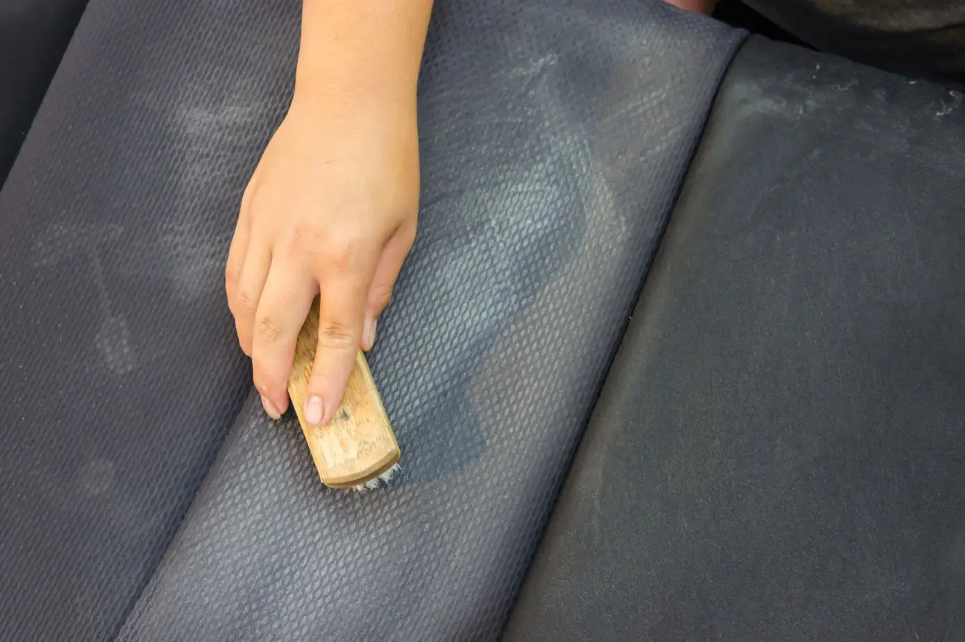 woman scrubbing an upholstered seat with a hard brush