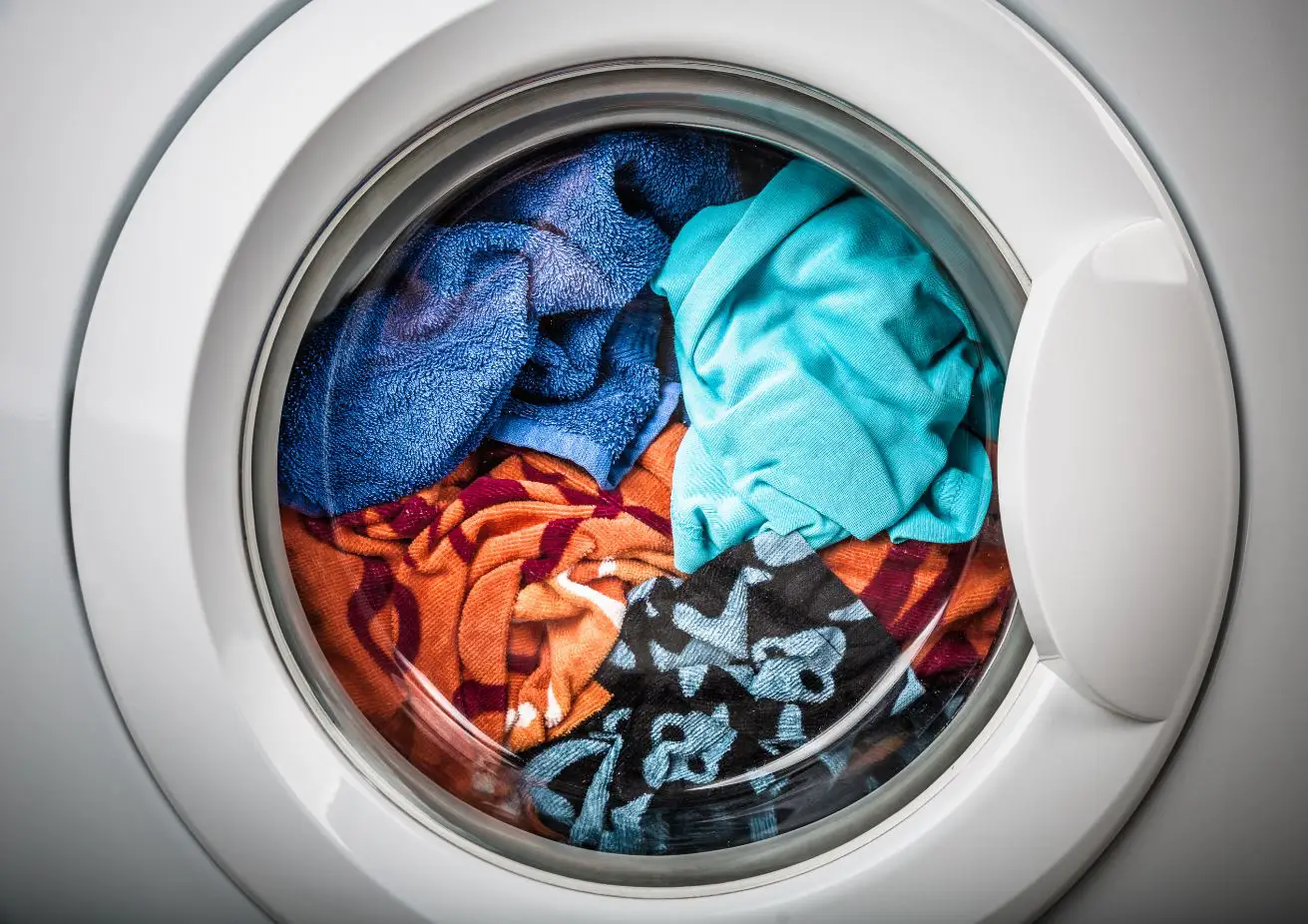 multicoloured clothes in a front loader washing machine