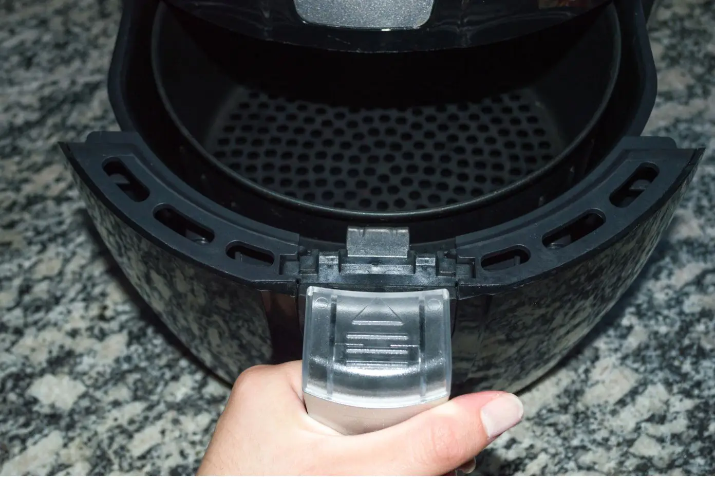 man opening air fryer to show air frying basket