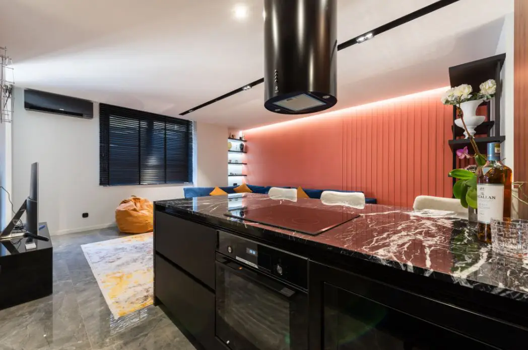 all black inspired modern kitchen with a large granite benchtop