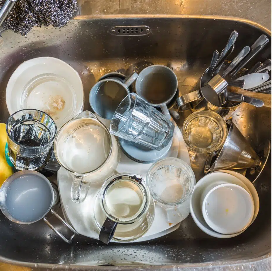 kitchen sink fill of dirty cutlery and cups