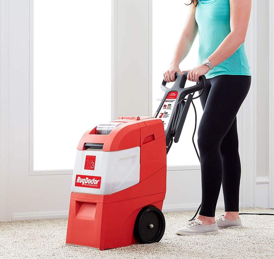 woman in teal shirt using rug doctor on carpets