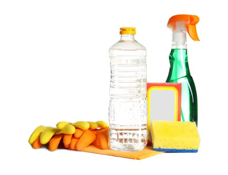 bottle of white vinegar standing next to green multipurpose cleaner, sponge and orange gloves