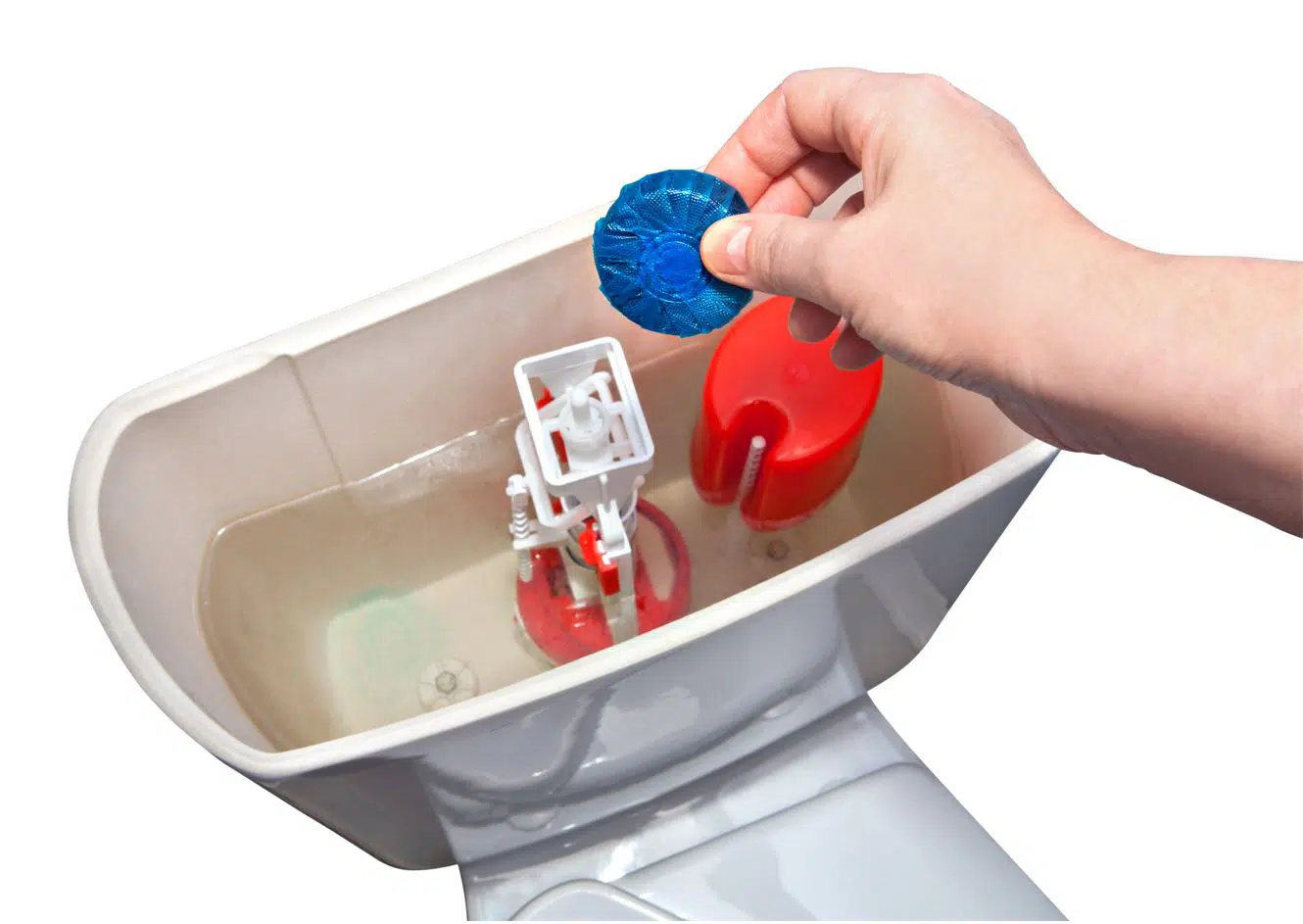 man placing cleaning tablet in white porcelain toilet tank
