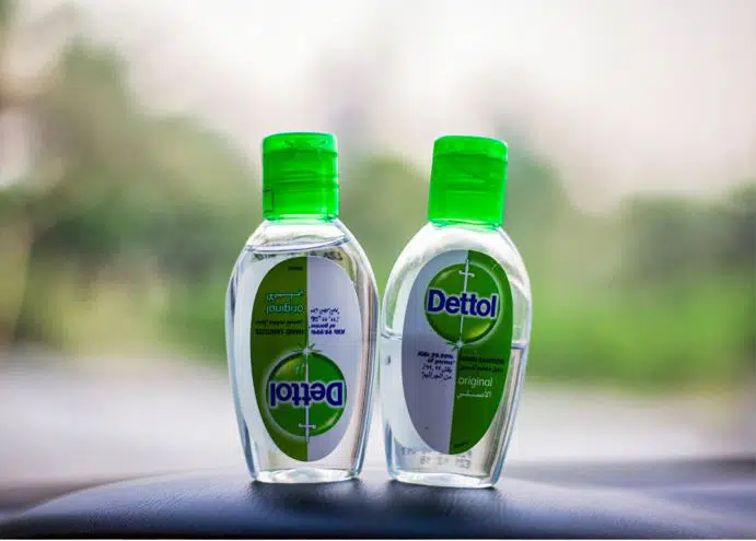two bottles of dettol hand sanitiser on a car dashboard