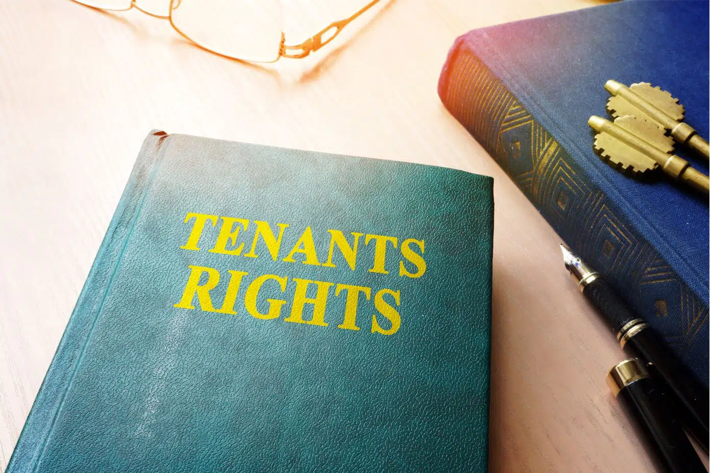 a green covered book titled tenants rights sitting on a wooden desk