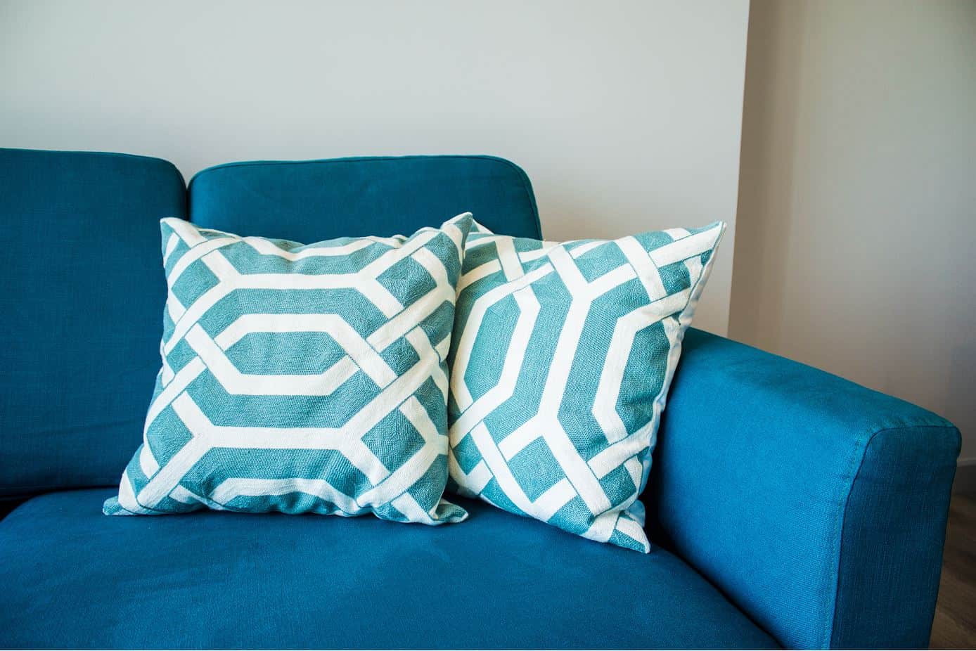 two light blue cushions propped up on a blue upholstered couch