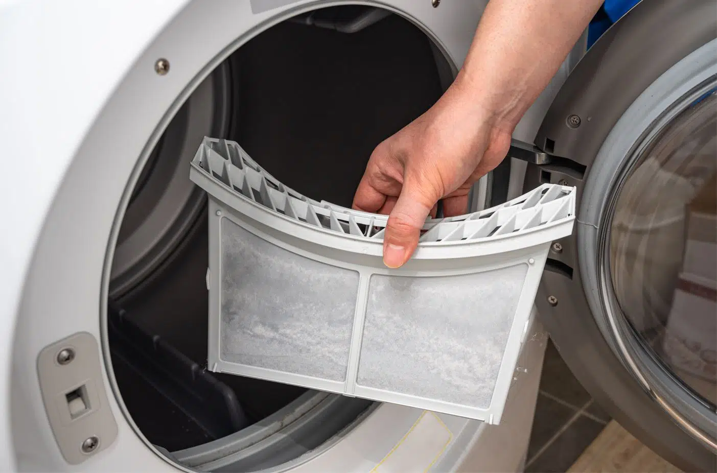 man holding filter trap in front of dryer