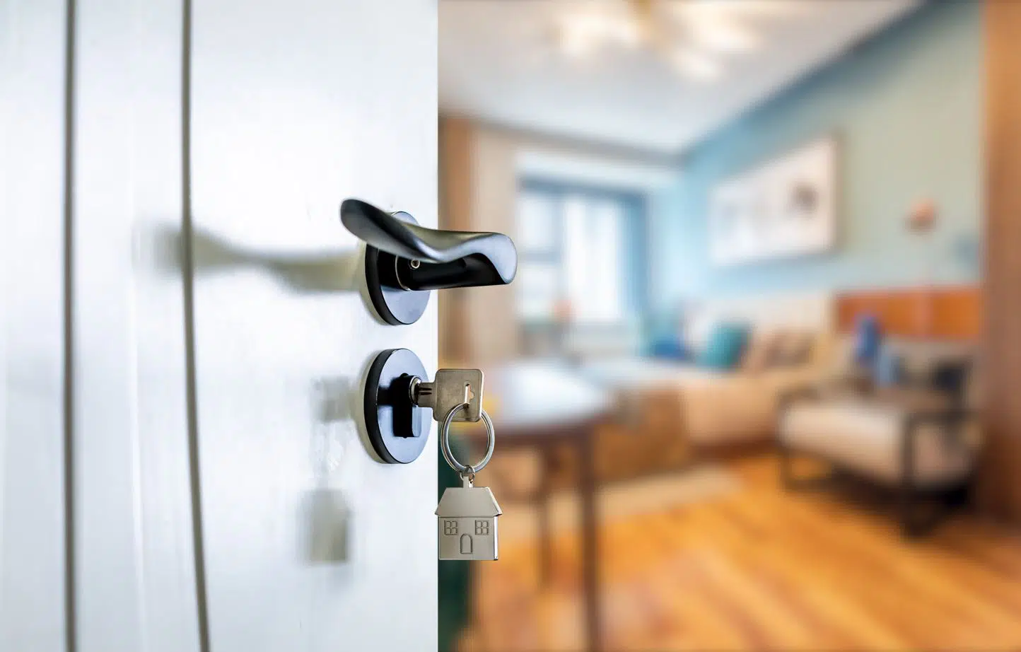 chrome door with black handle open to a large living room