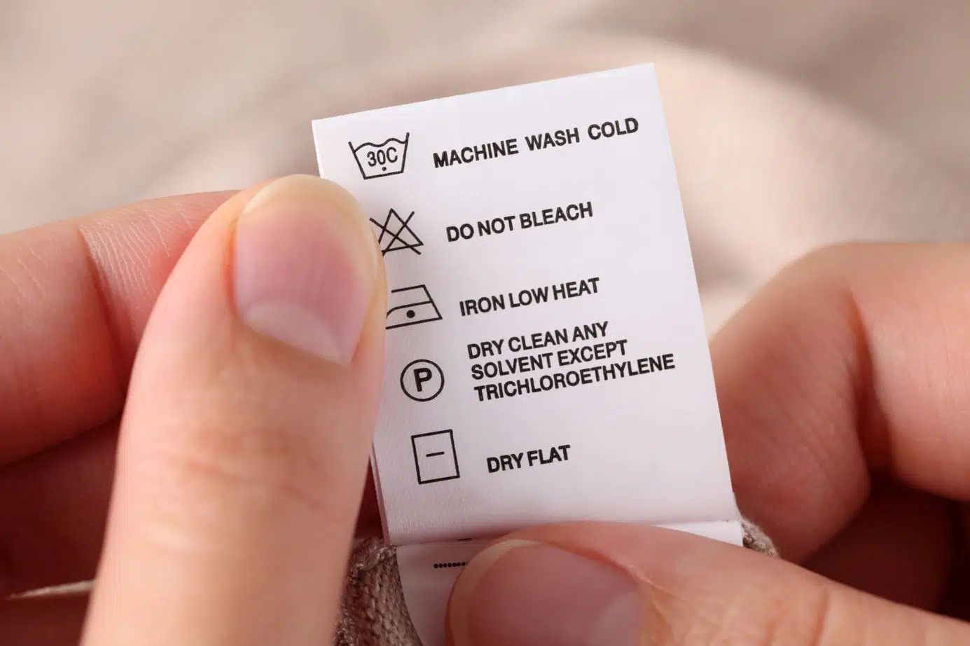 woman holding washing instructions for a hat