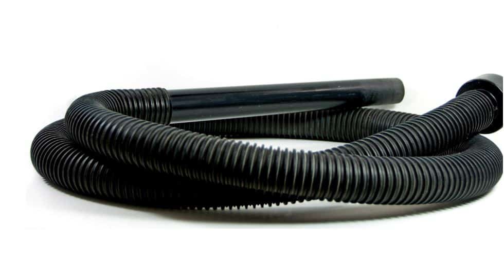 black vacuum hose curled up on the floor on a white background
