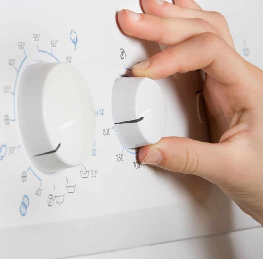man changing settings on his washing machine