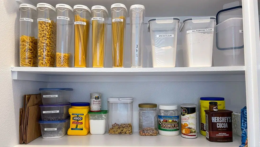 kitchen pantry with pasta stacked in plastic containers on two levels