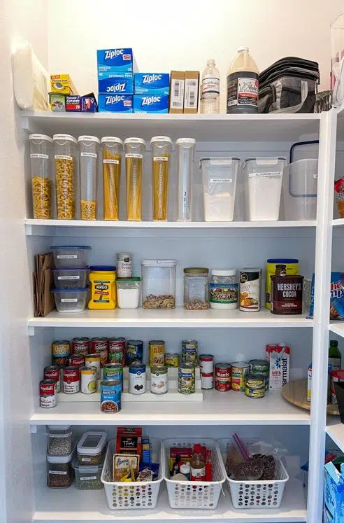 large well organised all-white pantry with assorted food items on every shelf