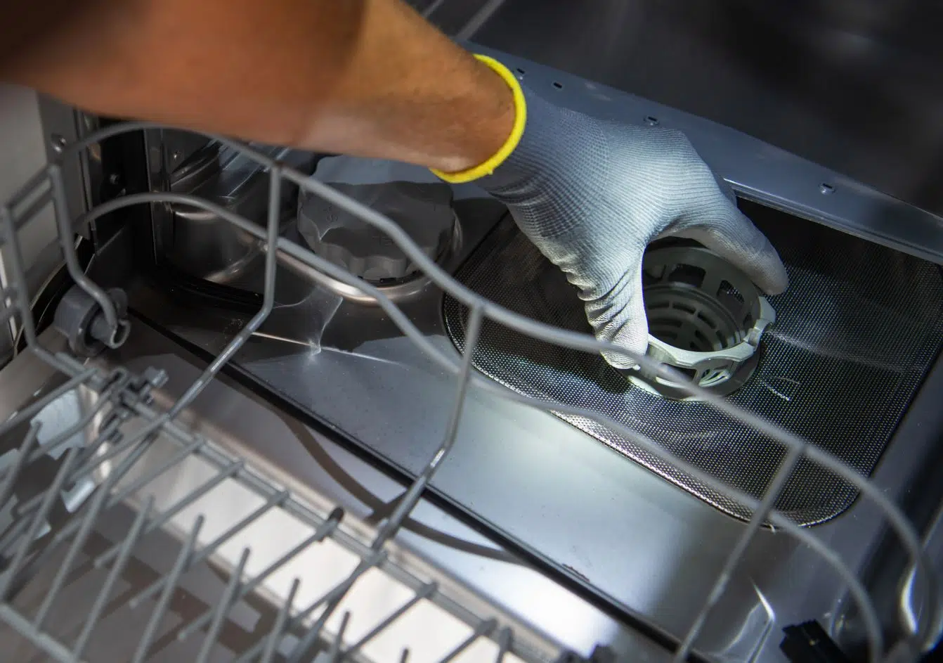 man adjusting filter in brand new dishwashing machine